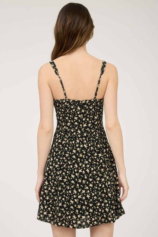 Woman wearing a black floral dress against a white background